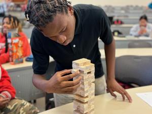 Close-up student moving Jenga blocks in Project Management activity